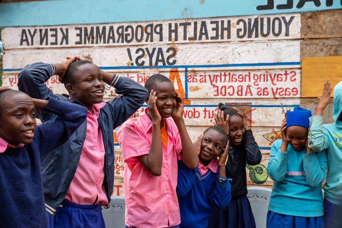  Group of children smiling with their hands on their heads 